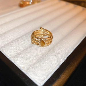 Detail of gold-plated dragon ring with layered band and teardrop tiger eye gemstone