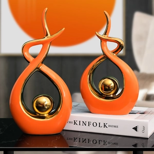 Modern luxury orange ceramic art sculptures with gold spheres on black marble table