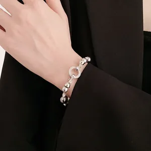 Elegant dark grey pearl bracelet with zircon round clasp worn on a female wrist