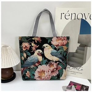Close-up of 3D ethnic floral embroidery and butterfly detail on black canvas tote bag