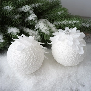 Pair of white Christmas ornaments with pearl beads and fabric flowers on snow branches