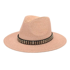 Detailed weave pattern on a straw sun hat with black studded leather band decor