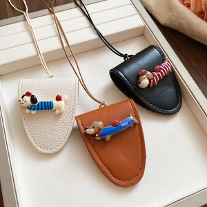Three leather dachshund dog key covers in beige, brown, and black on a display tray