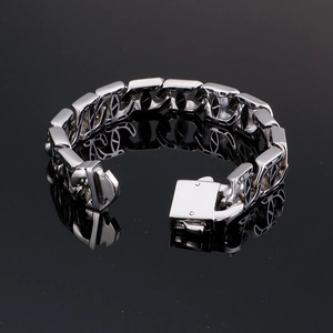 Macro shot of silver hip-hop curb chain bracelet featuring intertwined double C links