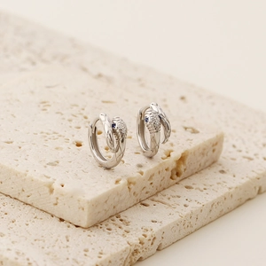 Detail of silver snake hoop earrings with micro-paved zircons and blue stone eyes