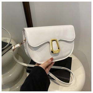 Detail view of a white PU leather saddle bag featuring golden metal buckles on a stand