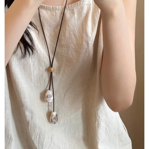 Détail du collier en cordon ciré avec perles de marbre blanc et curseur en bois