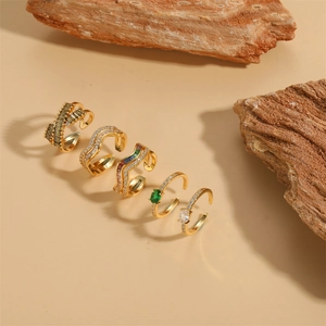 Five-piece gold adjustable ring set with colorful zircon stones on natural wood blocks
