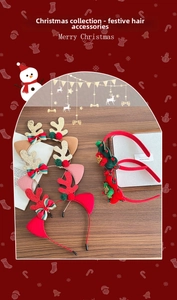 Detail of Christmas reindeer antler headband with festive bow and glitter accents