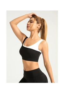 Detail of high-stretch sports bra with contrast black and white layered shoulder straps
