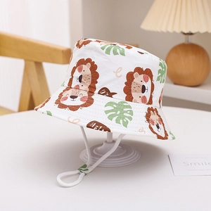 Detail of white cotton sun hat featuring cartoon lion prints and adjustable chin strap