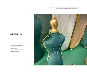 Detailed macro view of a gold geometric necklace on a dark green velvet display stand
