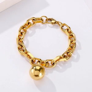 Detailed macro view of a gold stainless steel chunky chain bracelet with a hollow ball pendant