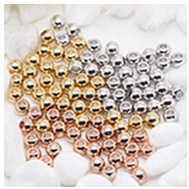 Macro detail of gold, silver, and rose gold metal beads for DIY jewelry making