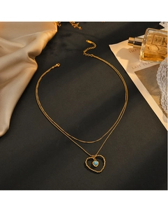 Détail du collier cœur doré double épaisseur avec pierre turquoise et décor élégant