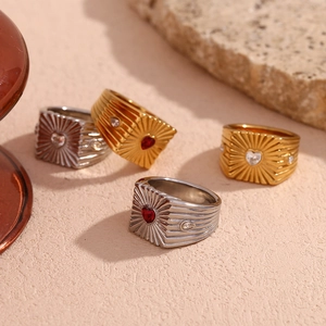 Detail of vintage signet rings with heart stones and sunburst texture in gold and silver