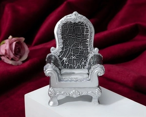 Macro shot of silver vintage crown jewelry display stand with grey velvet cushion