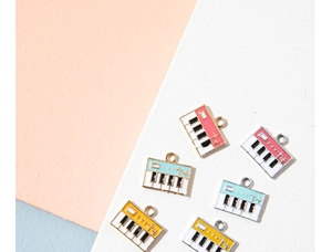Macro shot of colorful alloy piano keyboard pendants with musical note charms for DIY jewelry