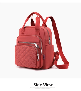 Detail view of red nylon backpack with diamond quilting and multi-pocket zippers