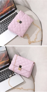 Close-up of pink quilted crossbody bag with gold chain strap and square metal lock