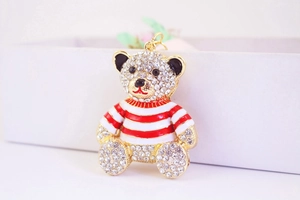 Detailed macro view of the rhinestone-studded teddy bear pendant with striped red sweater