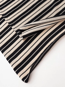 Close-up detail of linen-textured striped knit fabric showing intricate weaving and layers