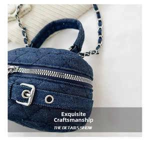 Detail of dark blue denim quilted crossbody bag with silver chain and metal hardware