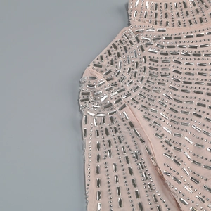 Detailed view of high-density rhinestones on sheer nude mesh fabric of a sexy dress
