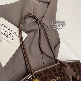Détail du grand sac cabas léopard avec lanières en cuir marron et texture peluche