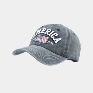 Macro shot of embroidered America text and US flag on vintage washed gray baseball cap