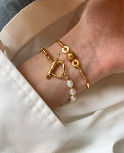 Macro view of 18K gold-plated bamboo link bracelet with freshwater pearls and toggle clasp