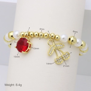 Dettaglio del bracciale con perline, gemma rossa e ciondoli a ciliegia con dimensioni