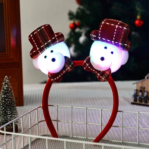 Detail of LED glowing snowman headbands with red plaid hats and festive holiday lights