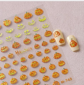 Detail of Halloween nail stickers with gold pumpkin face patterns and embossed texture
