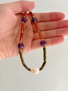 Macro shot of colorful beaded necklace with baroque pearl and semi-precious gemstones