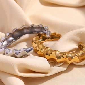 Close-up of gold and silver twisted spiral bamboo bracelets on beige satin fabric
