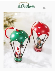 Detailed view of metal Santa and deer hot air balloon Christmas ornaments on snow