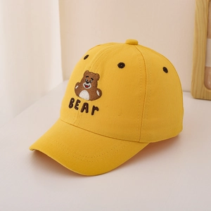 Close-up of cute cartoon bear embroidery and BEAR text on a yellow kids baseball cap