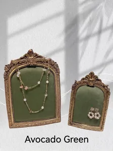 Detailed view of avocado green velvet jewelry display stands with gold vintage frames
