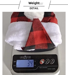 Detail view of plaid Christmas hat weighing 34g on a digital scale for size reference