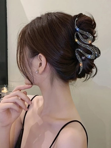 Detail of dark grey wavy hair claw clip with rhinestones and pearls on hair
