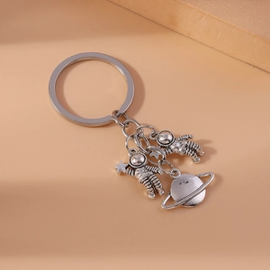 Creative silver astronaut and planet keychain accessory for bags with vintage metal finish