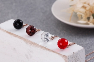 Macro view of multi-color faceted crystal pendants on elegant rose gold chains