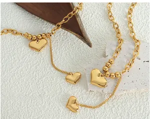 Détail du pendentif double cœur en titane plaqué or 18 carats avec une grosse chaîne