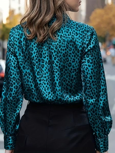 Detail view of the turquoise leopard print satin shirt fabric from a back perspective