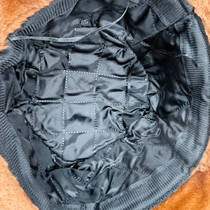 Dettaglio della fodera trapuntata a rombi e punti argentati all'interno del cappello invernale
