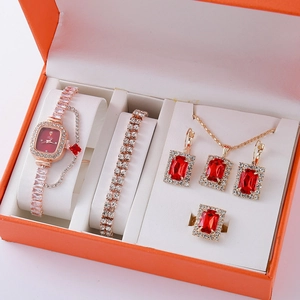 Luxurious rose gold jewelry set with red gemstones in a premium orange gift box