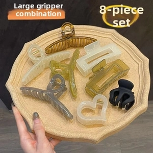 Detail of 8-piece acrylic hair claw clips set in various colors on a stone tray