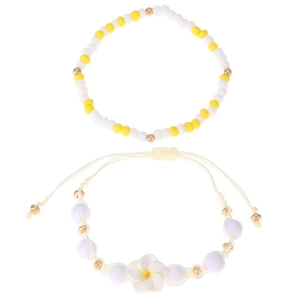 Dettaglio del set di braccialetti con perline gialle e bianche e ciondolo a fiore di frangipane