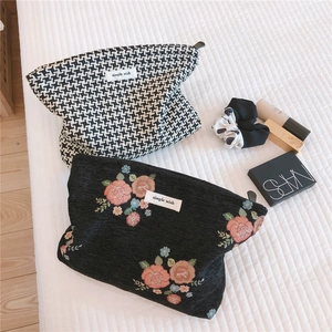 Detail showing vintage houndstooth and floral embroidery fabric texture with zipper
